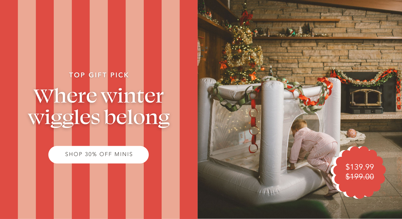 Kid crawling into Mini Bounce House decorate with paper chains, sitting next to a Christmas tree. Top Gift Pick: Where winter wiggles belong | Shop 30% off Minis