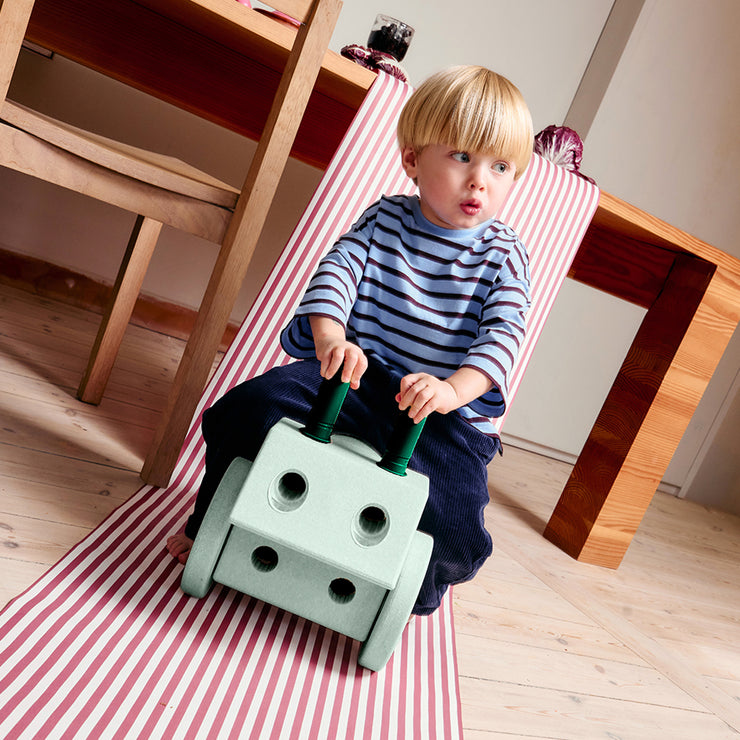 Kid sitting on ride on built with green MODU blocks